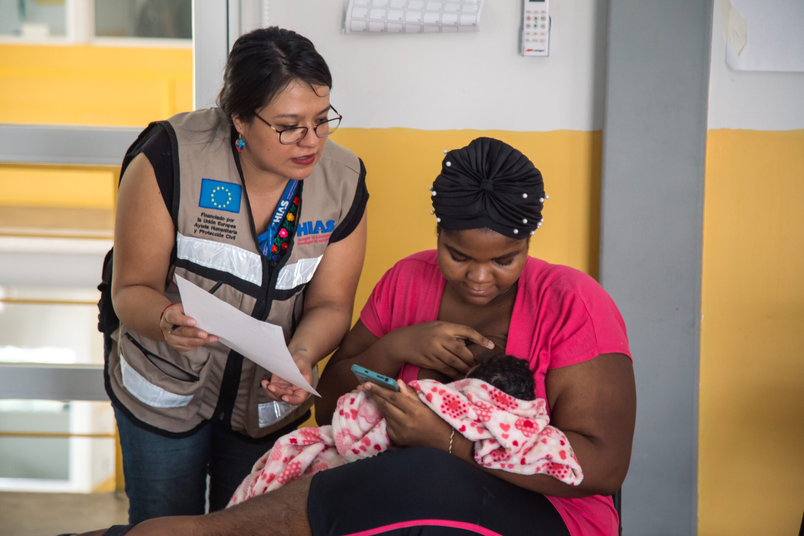 Paula García, a staff member of HIAS Mexico, provides assistance to Darle from Haiti during a workshop held at the 